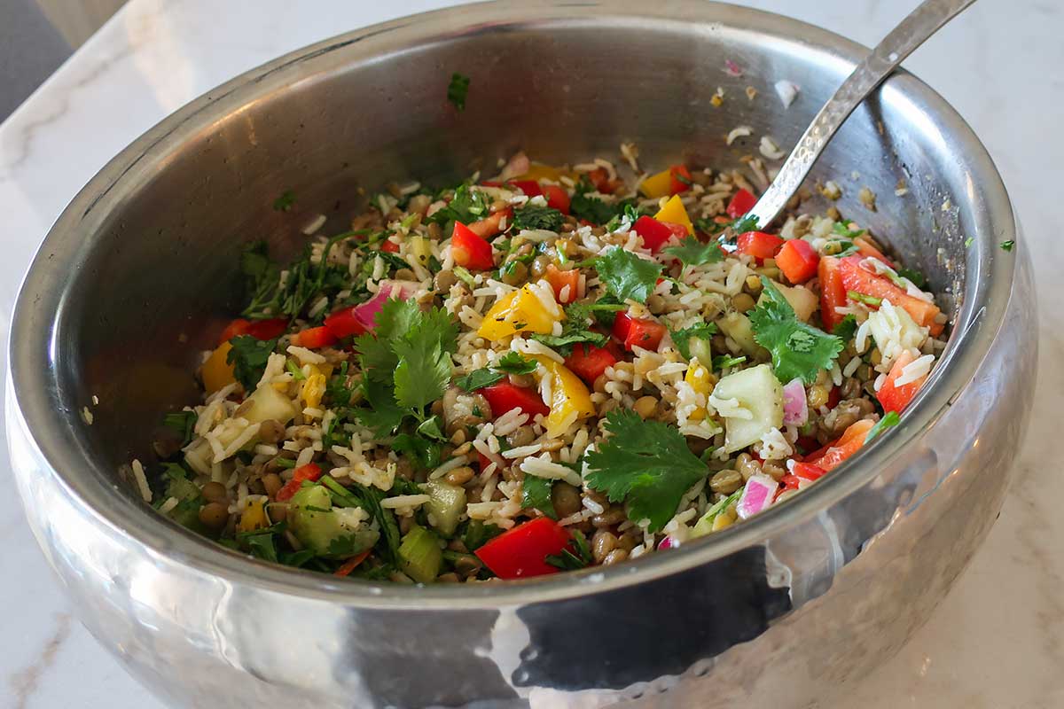lentil and rice mixed with veggies, herbs and a light vinaigrette in a bowl