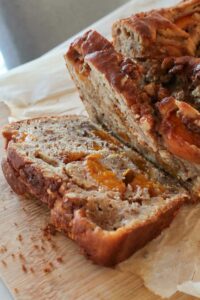 showing a slice of a gluten free apricot walnut quick bread on a cutting board