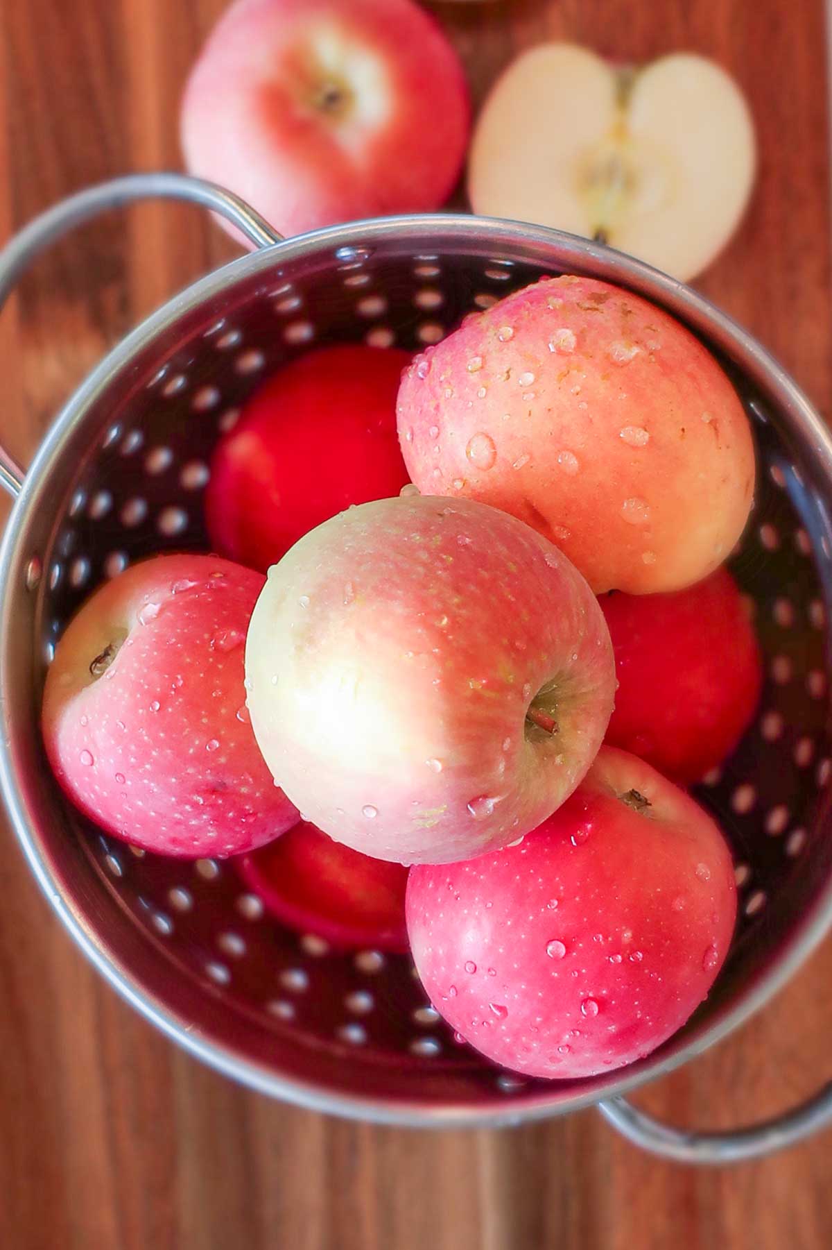 colander filled with apples on a cutting board