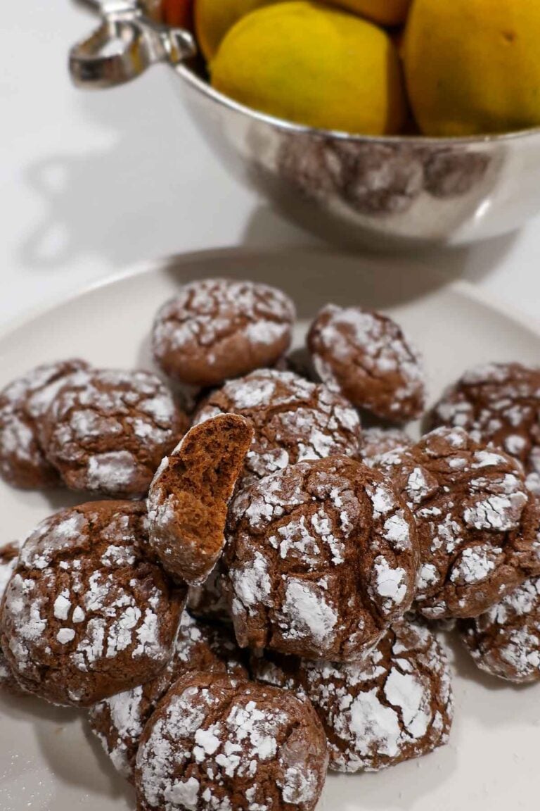 A platter of freshly baked gluten-free chocolate crinkle cookies, dusted with powdered sugar and ready to serve for the holidays