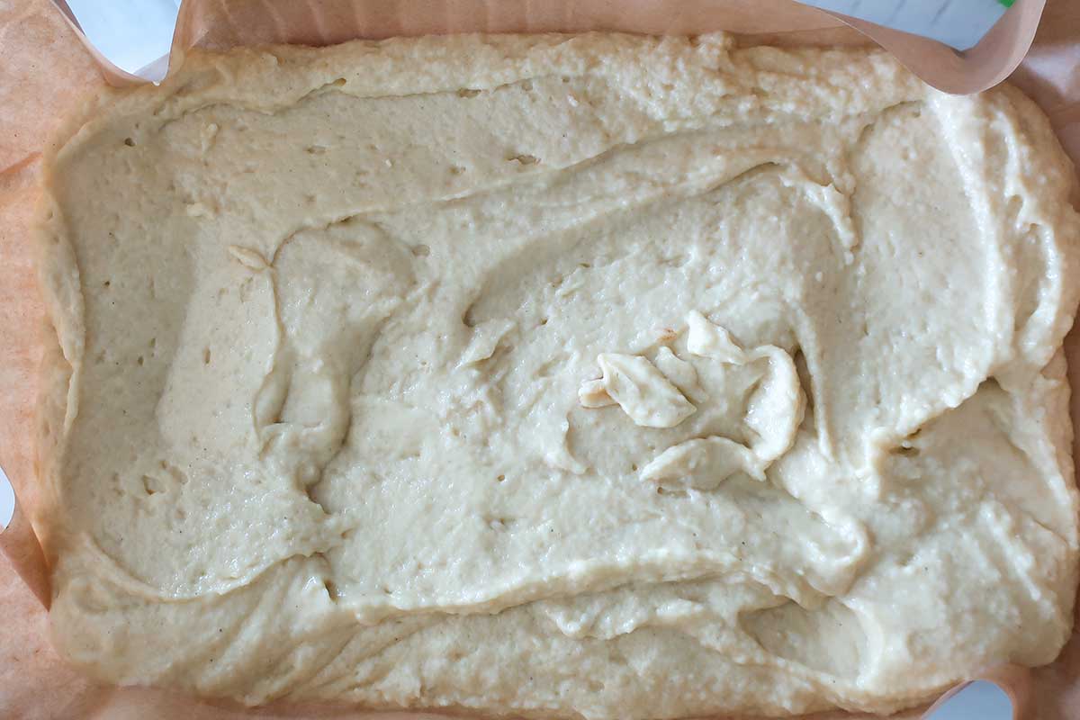 apple pecan yogurt cake batter spread in a baking dish