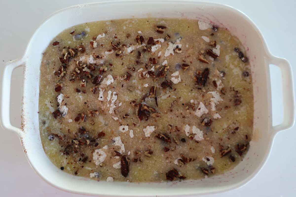 berry dump cake drizzled with butter before baking