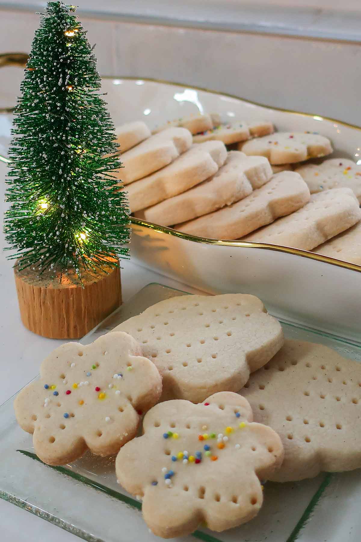 shortbread cookies presented on a cookie platter with a small Christmas tree in the background
