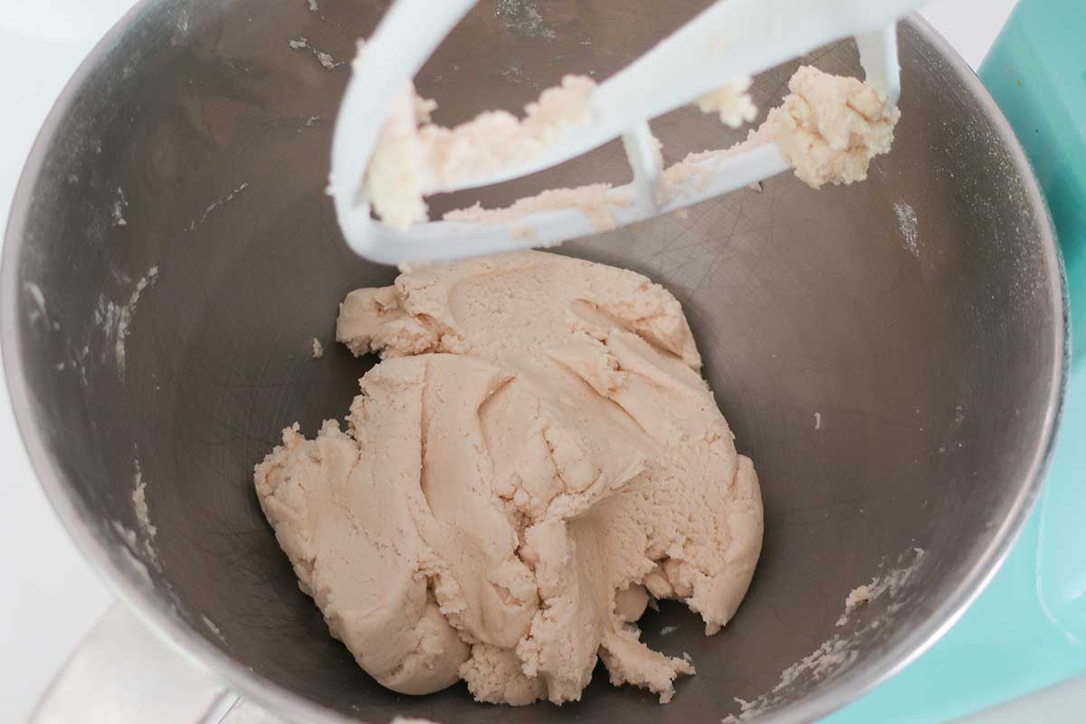 firm shortbread cookie dough in a mixing bowl with dough hook