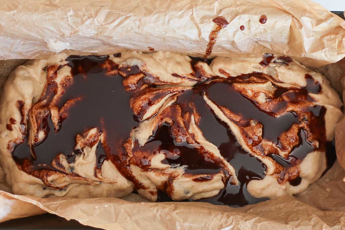 batter in a baking pan with cinnamon butter swirls throughout 