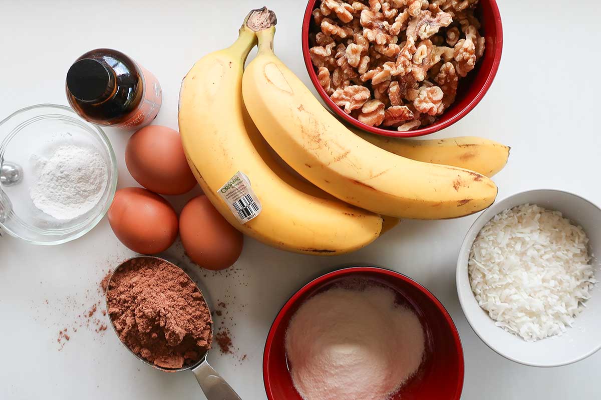 Ingredients for gluten-free chocolate banana cake: ripe bananas, eggs, cocoa powder, and walnuts