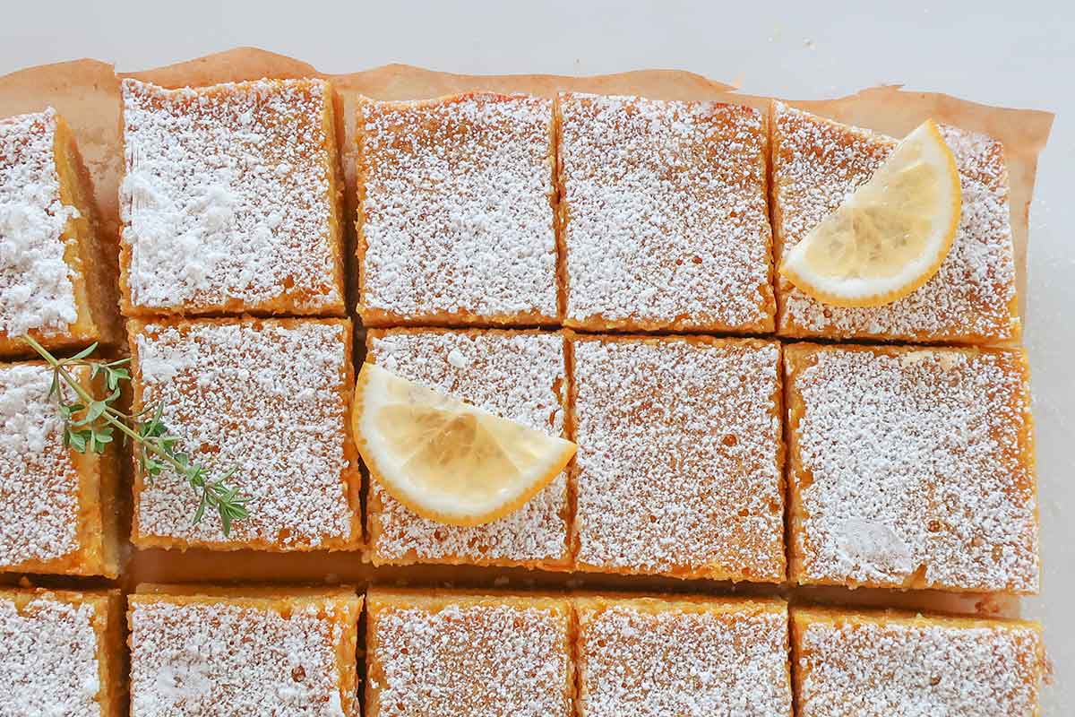 chilled sliced lemon bars dusted with powdered sugar and some topped with thin lemon slices