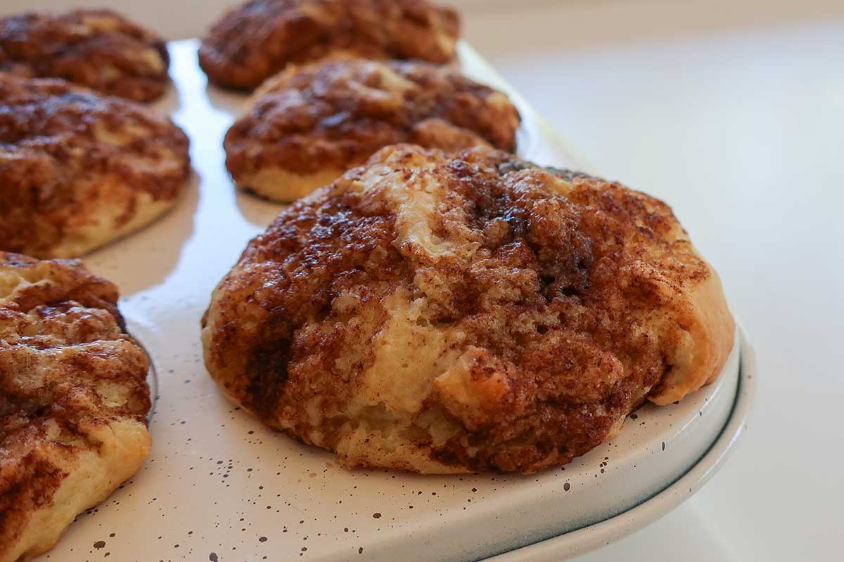freshly baked cinnamon swirl moist moist gluten free muffins in a muffin pan