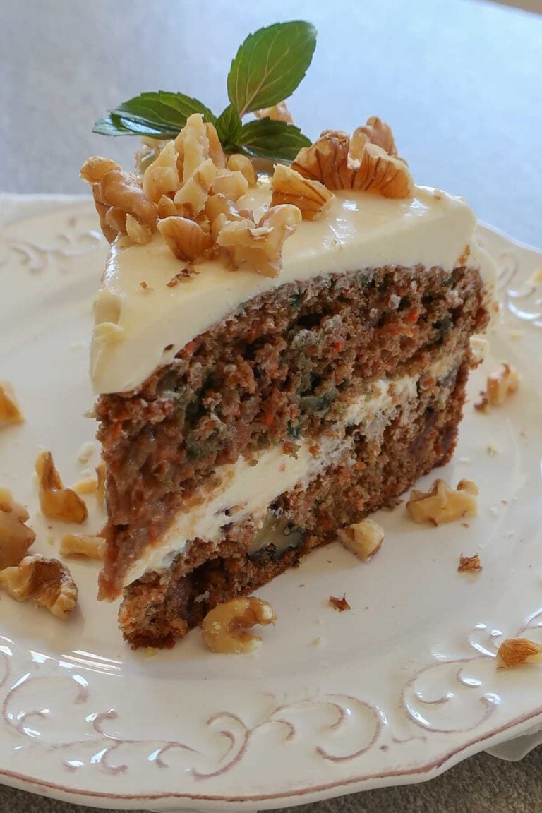 slice of GF carrot cake with cream cheese frosting, dates and chopped walnuts