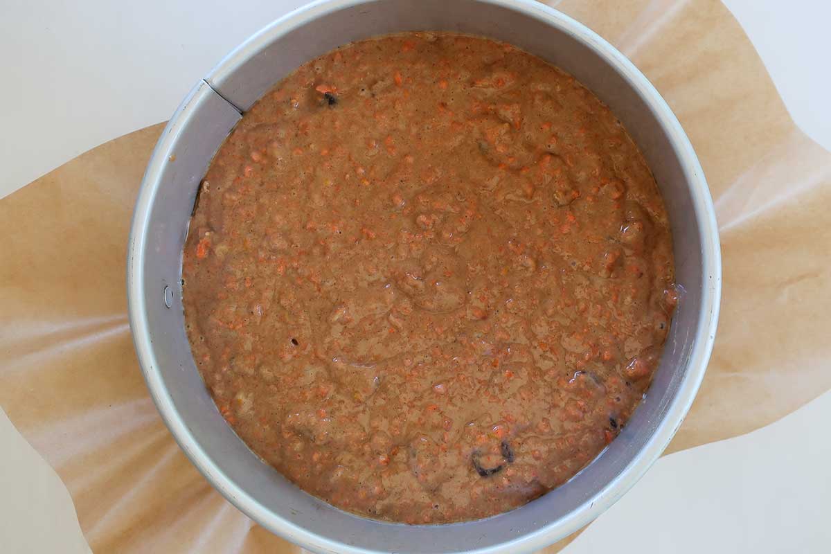 carrot cake batter in a lined springform pan before baking
