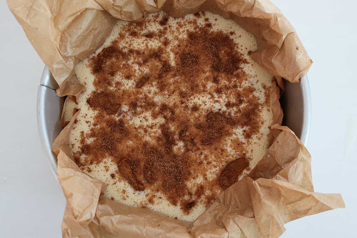 Custard cake batter in lined springform pan before baking, gluten-free dessert