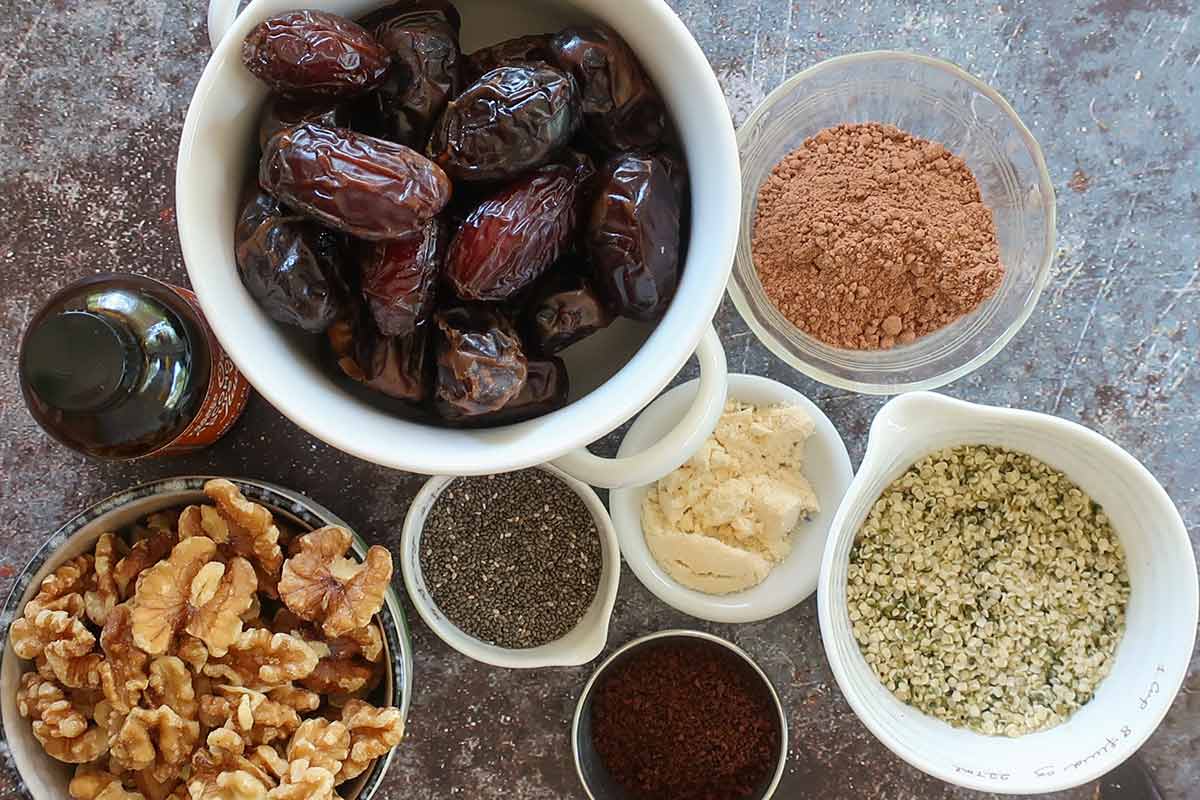 ingredients, dates, cocoa, hemp, walnuts, coconut flour, vanilla, chia, sea salt in bowls