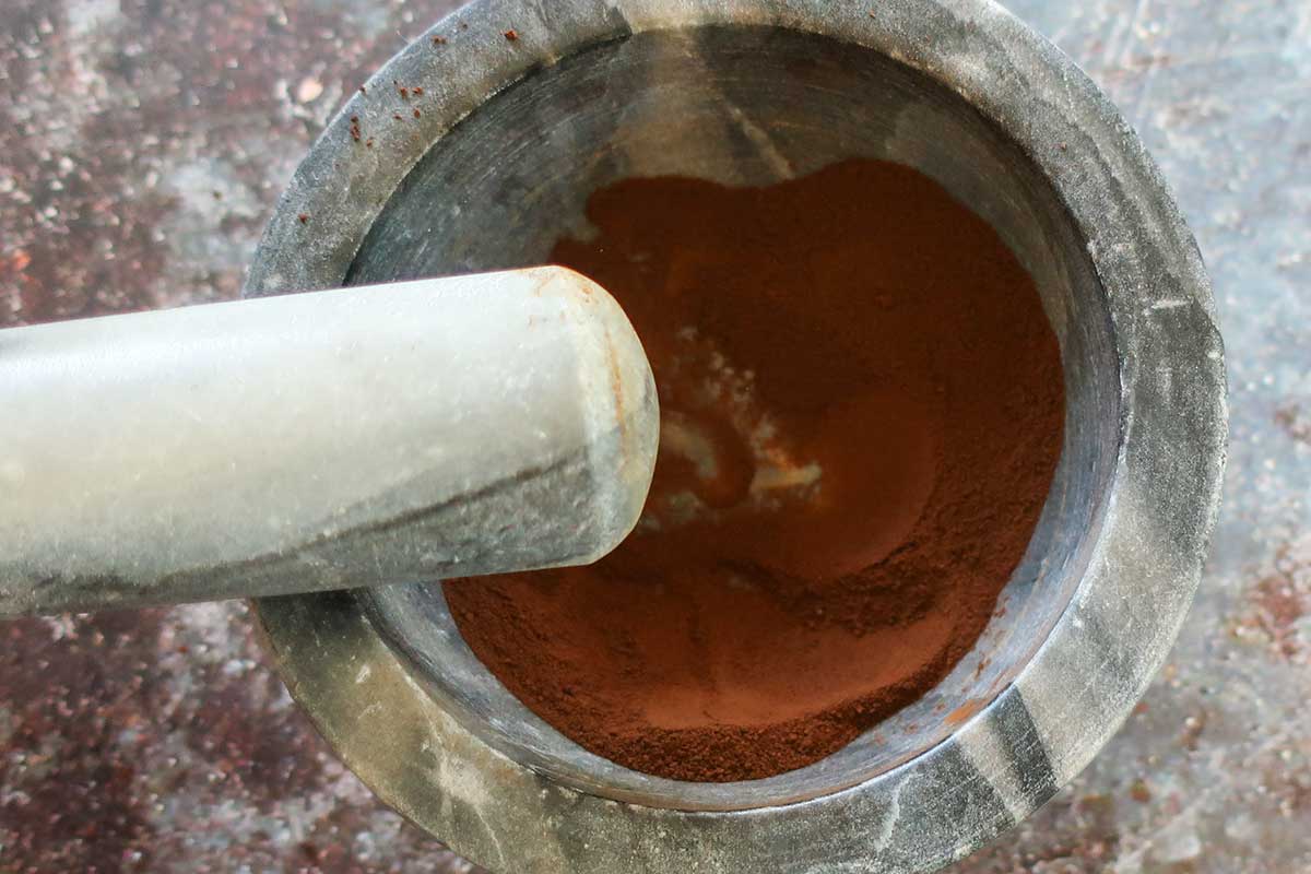 grinding granulated freeze dried coffee granules in a mortar