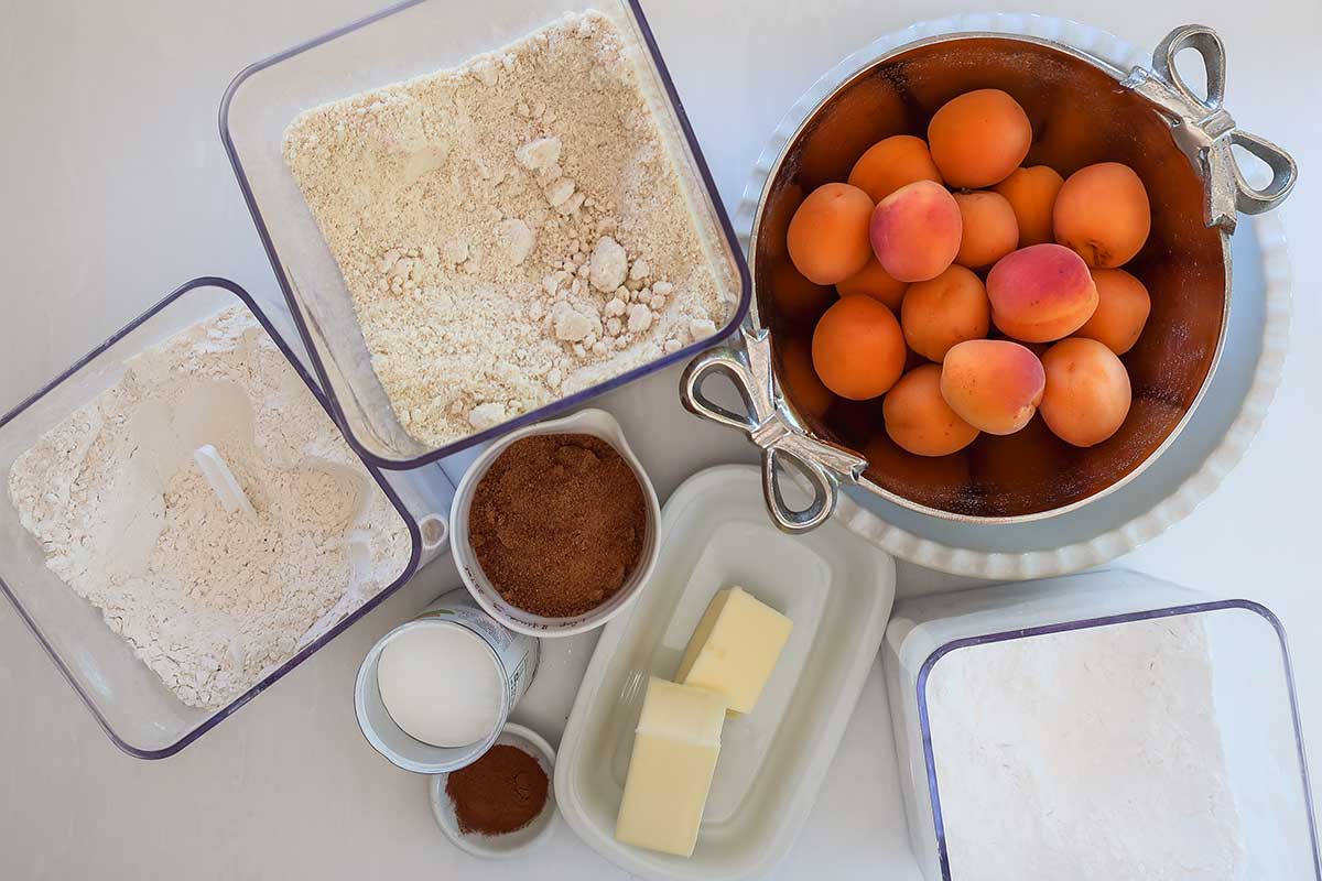 flour blend, almond flour, coconut sugar, butter, cinnamon, tapioca and fresh apricots the ingredients for Gluten-Free Apricot Cobbler style dump dessert
