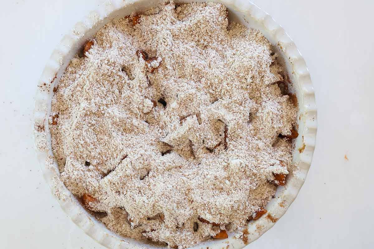 flavoured apricots in a deep pie dish topped with a mixture of flour blend, almond flour and baking powder 