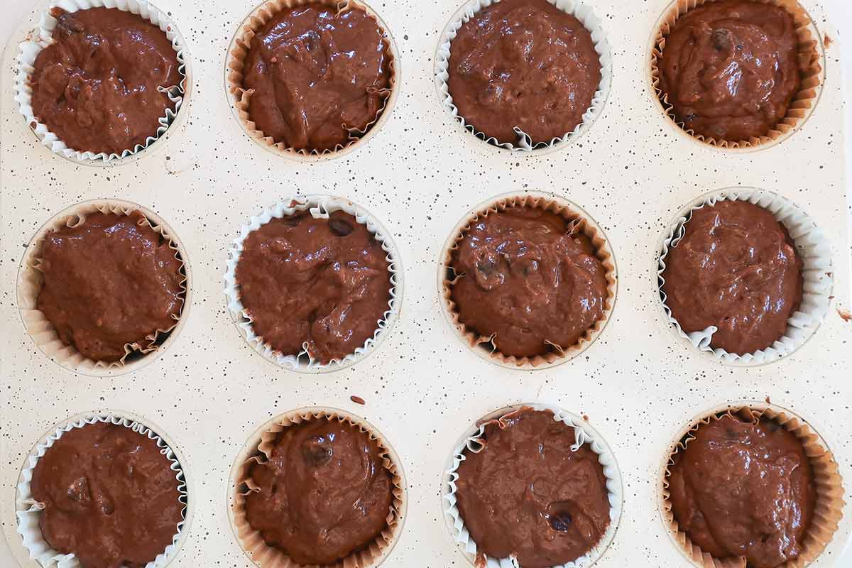 muffin pan lined with parchment paper and chocolate banana smooth batter