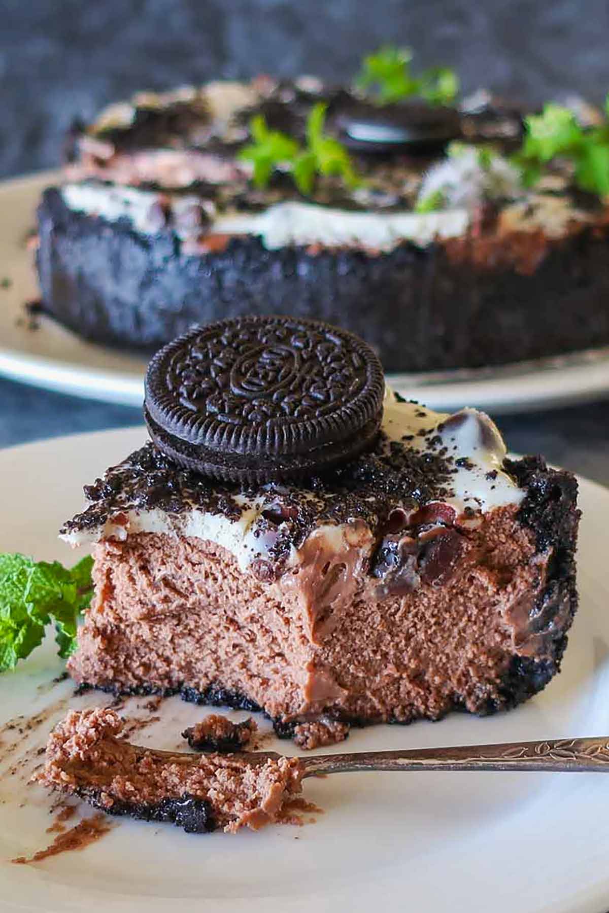 slice or baked Oreo cheesecake showing the silky smooth texture on a dessert plate