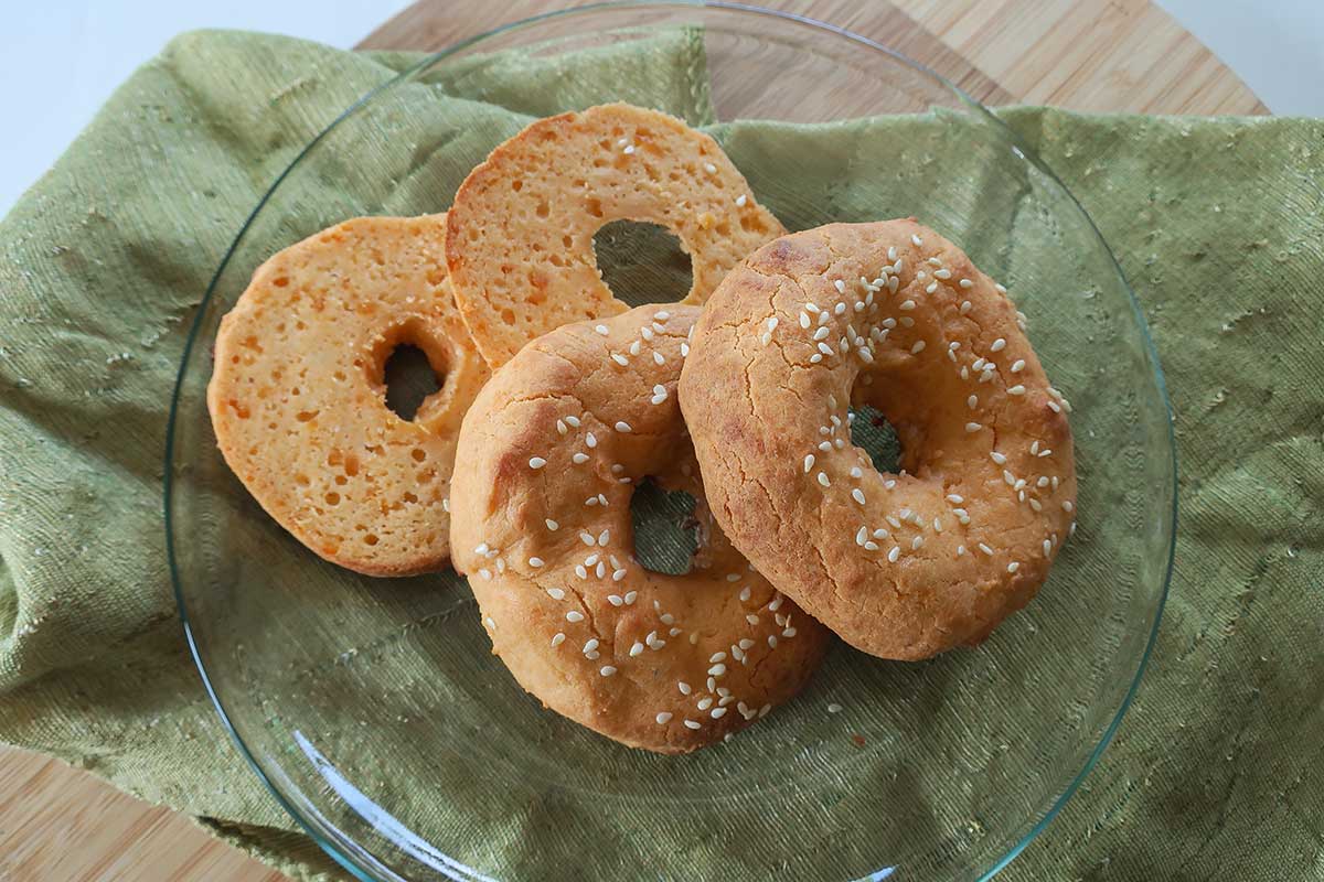 baked grain free low carb bagels with one sliced in half showing dense bagel texture