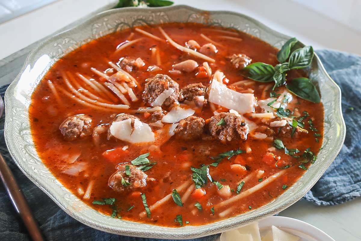 gluten free spaghetti meatball soup for kids in a bowl topped with extra parmesan