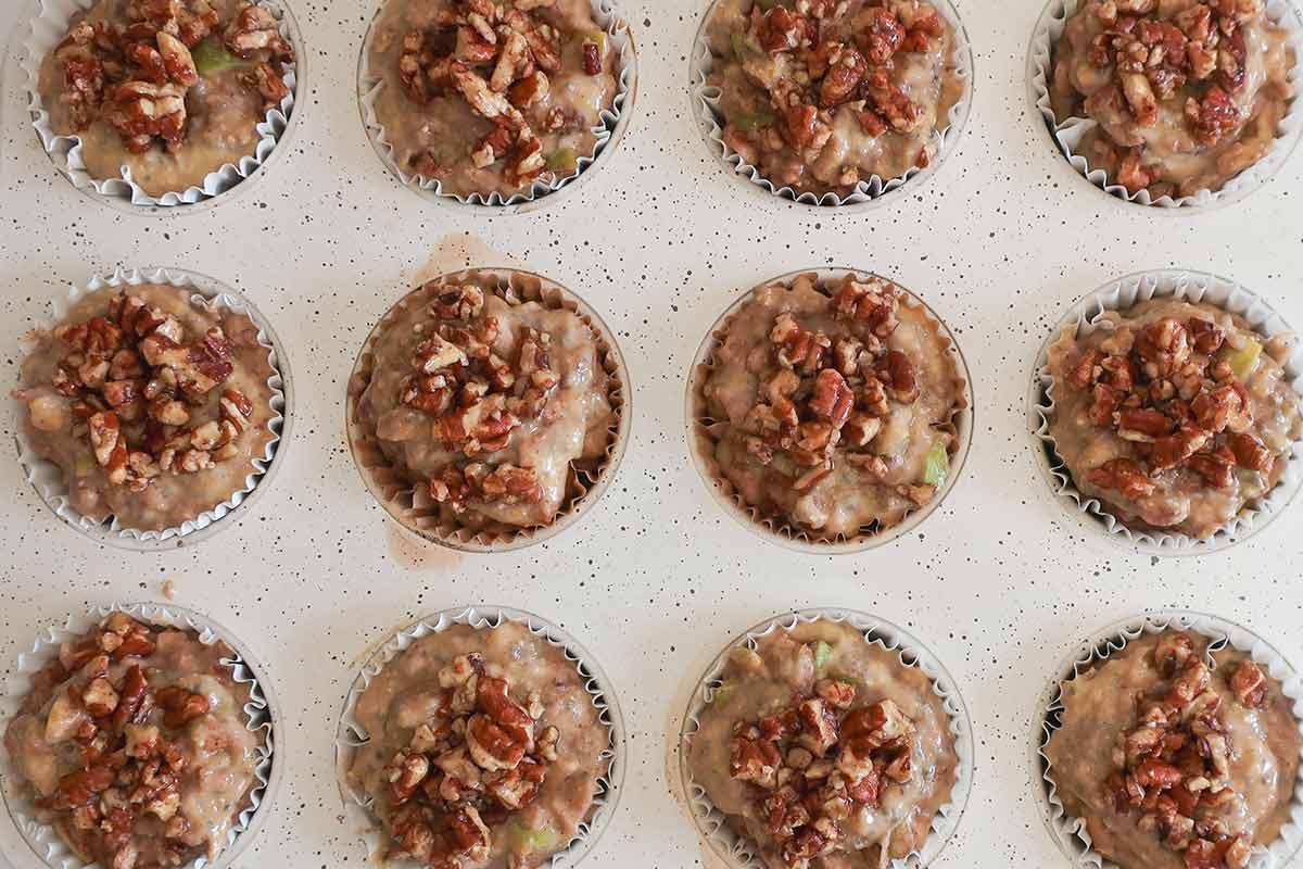 muffin batter in a muffin pan lined with parchment paper liners