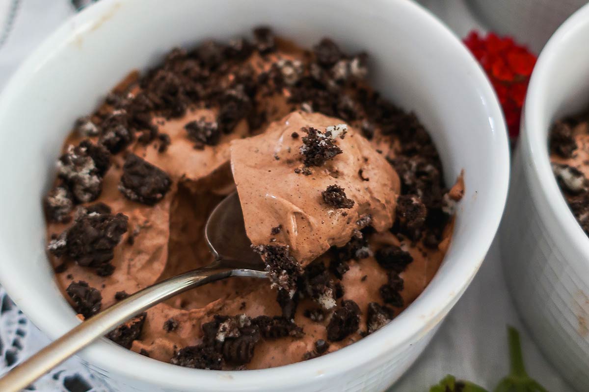 close up of the mousse texture on a spoon and cookie crumbs 