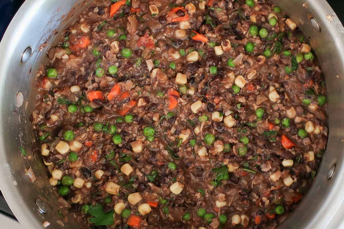 ground mushrooms, onions, black beans, corn, peas, carrots in a thick sauce ready for assembling pie