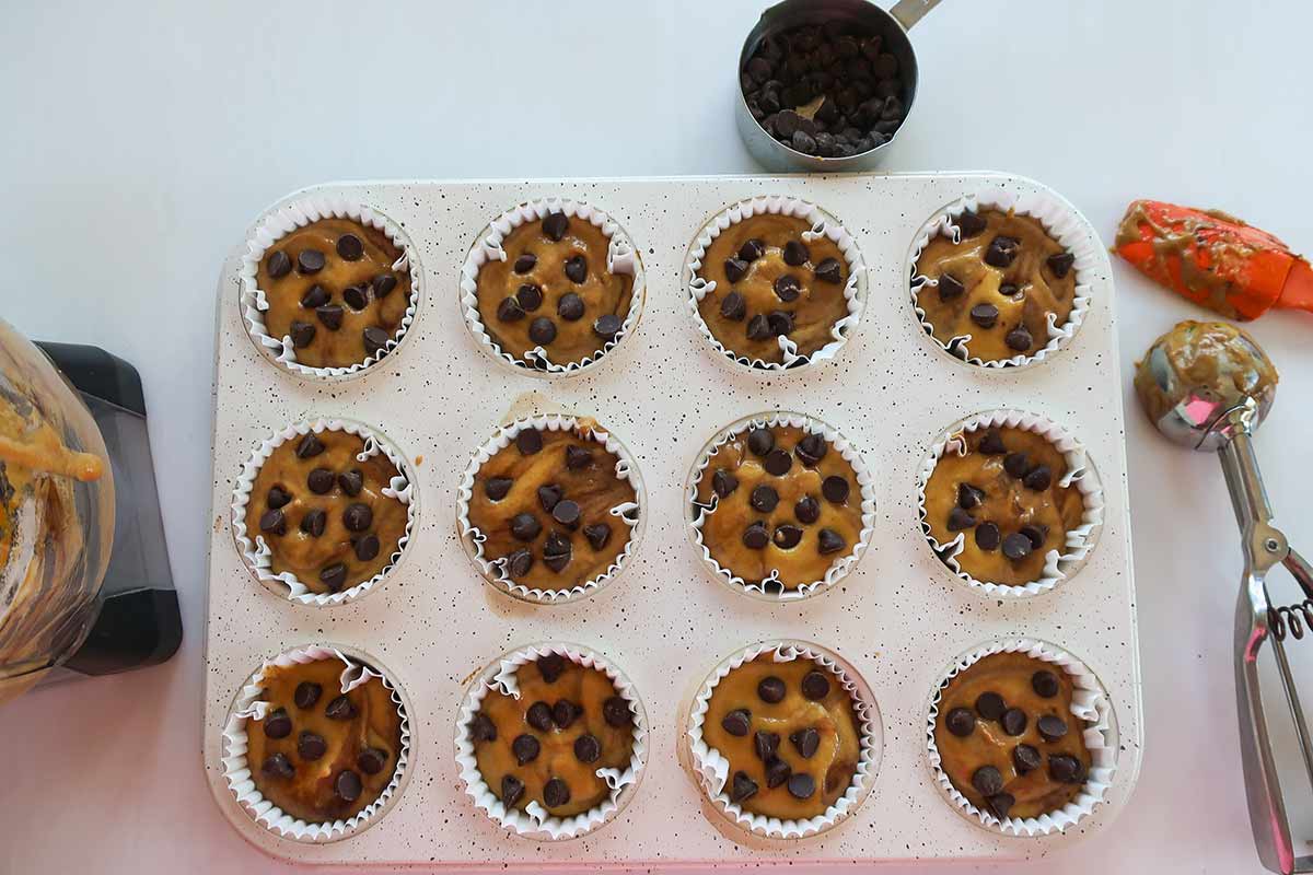 muffin batter in parchment paper liners topped with chocolate chips