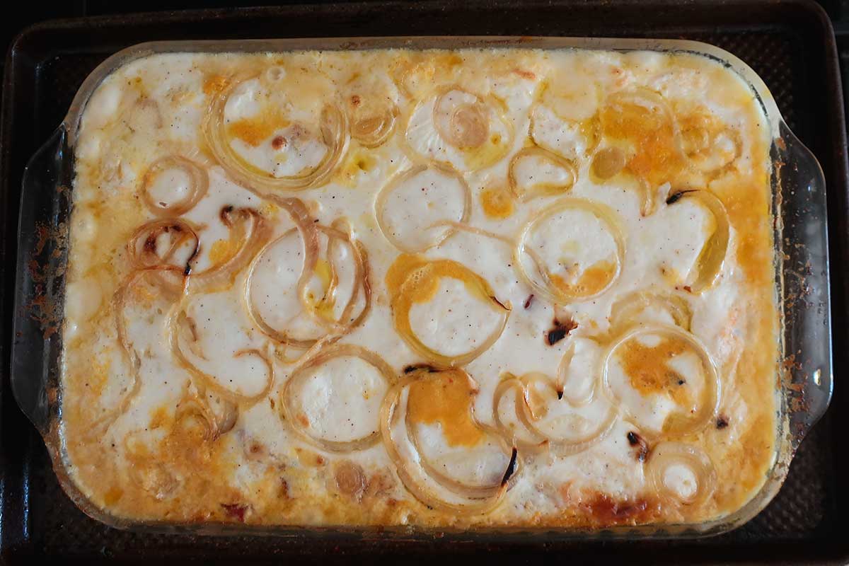 Freshly baked Grain-Free Sweet Potato Lasagna with Creamy Pumpkin Ricotta showing a golden top with caramelized onions