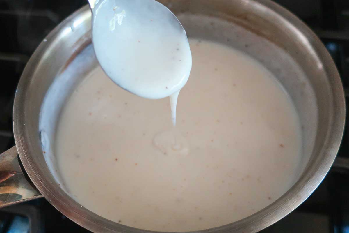 cooked béchamel sauce in a small saucepan showing the consistency